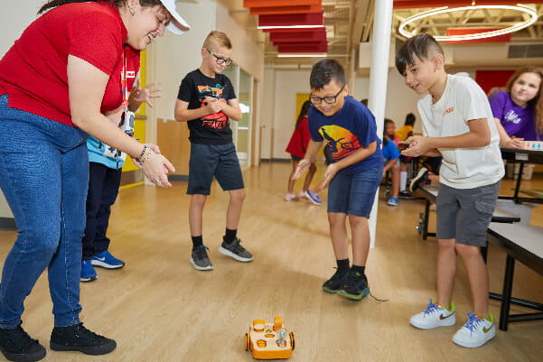 A group of kids playing with a toyDescription automatically generated